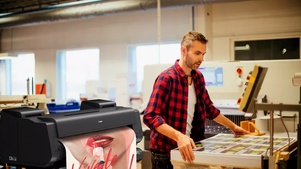 un profesionist imprimă diverse materiale cu ajutorul  plotter-ului Canon imageprograf gp 6600s